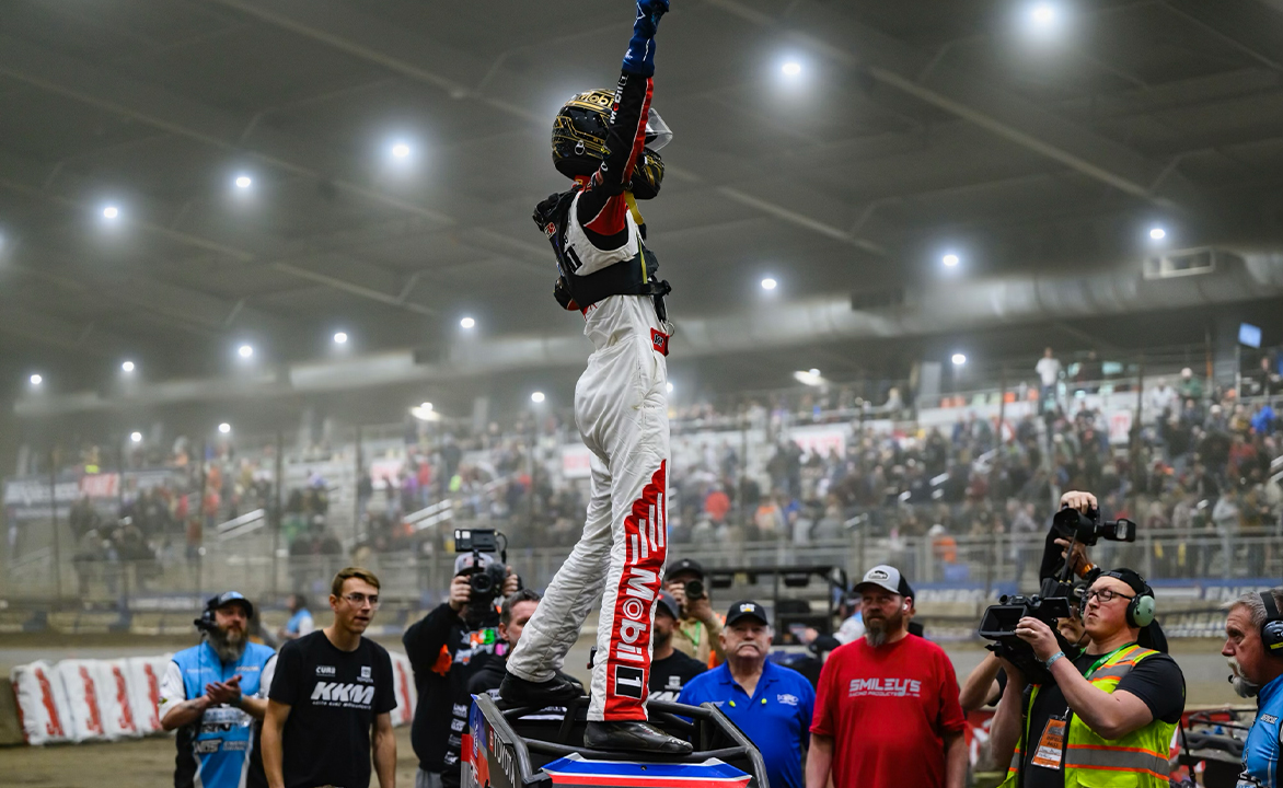 Buddy Kofoid stands atop a Keith Kunz Midget celebrating his 2024 Chili Bowl prelim win
