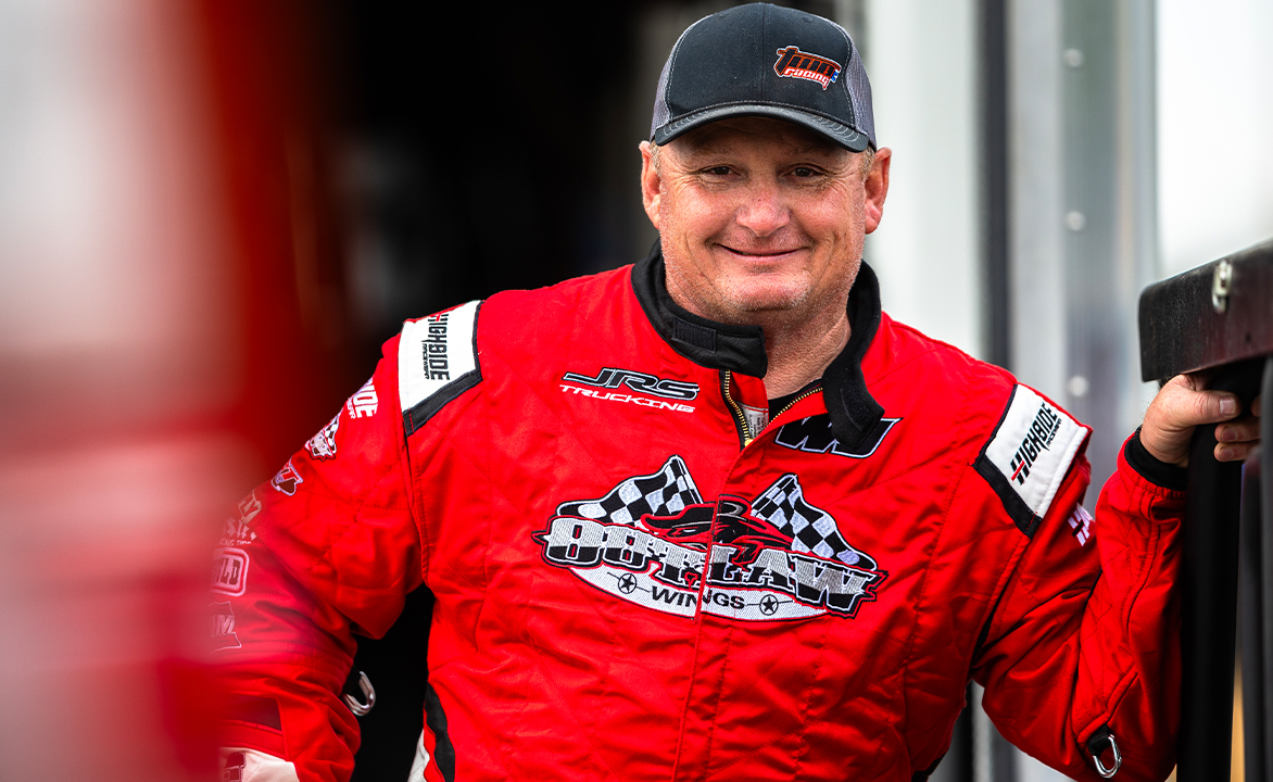 Wayne Johnson stands smiling by his trailer