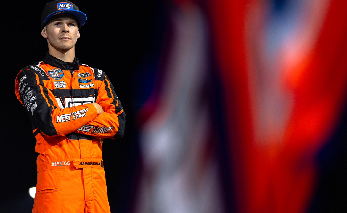 Sheldon Haudenschild stands atop his pit mule in his fire suit