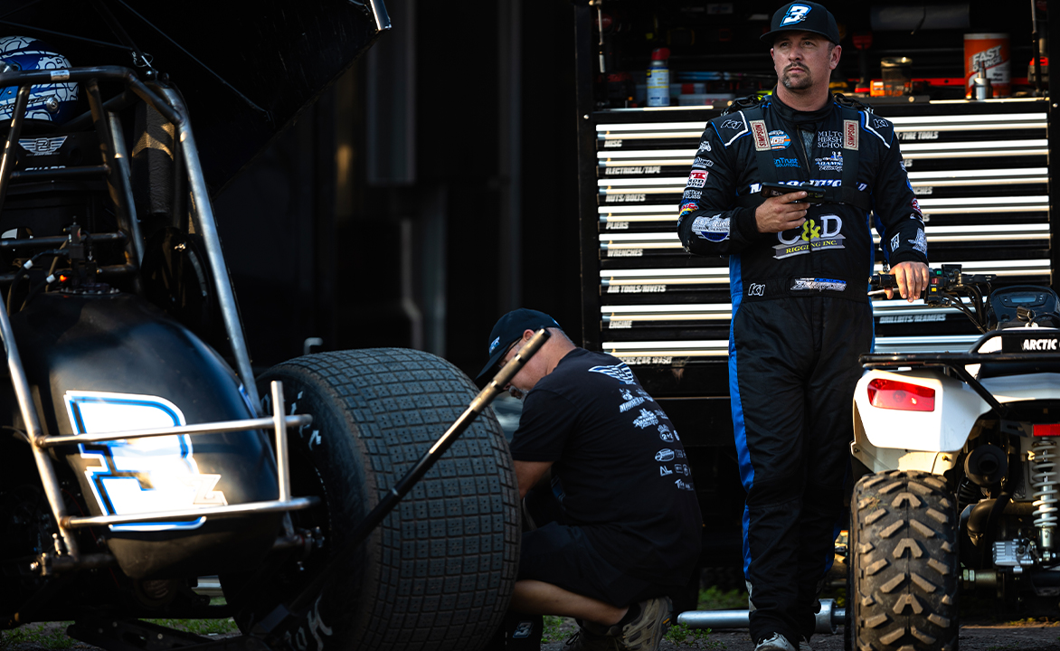 Brock Zearfoss stands in his fire suit next to his Sprint Car