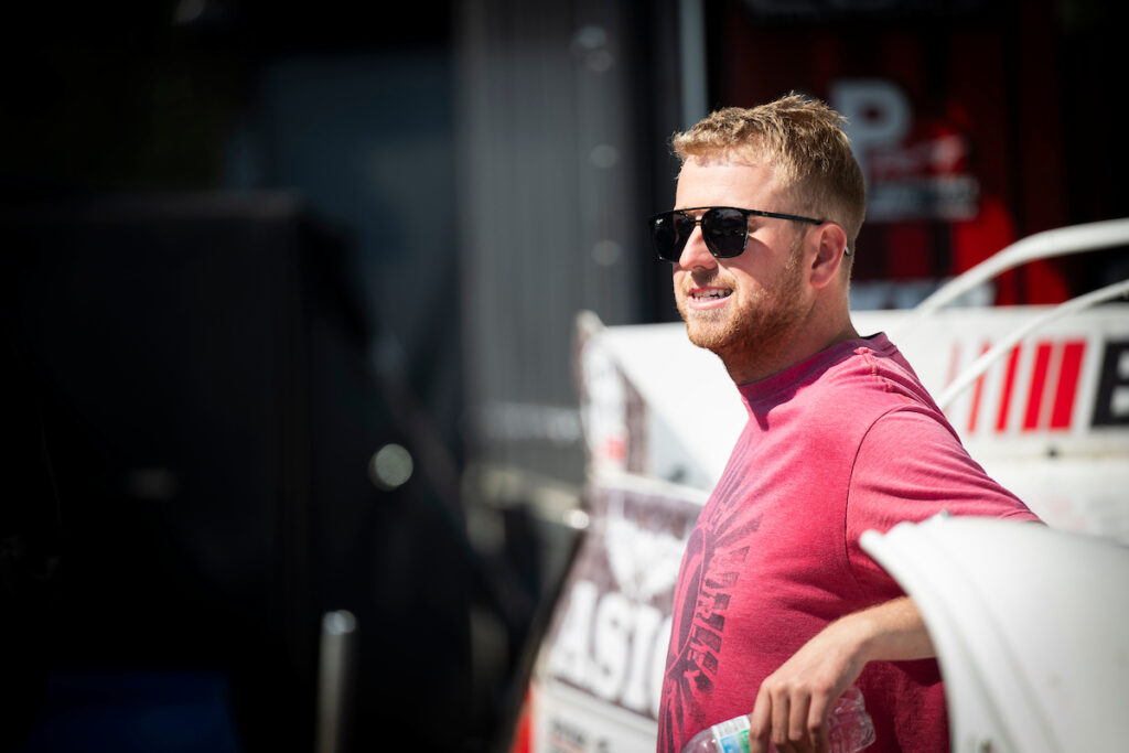 Dotson leaning on car