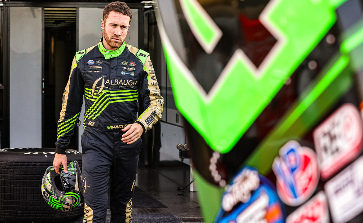Carson Macedo in his fire suit holding his helmet