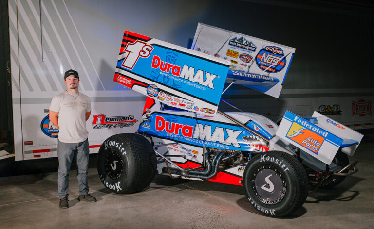 Logan Schuchart stands next to his 2026 Shark Racing Sprint Car